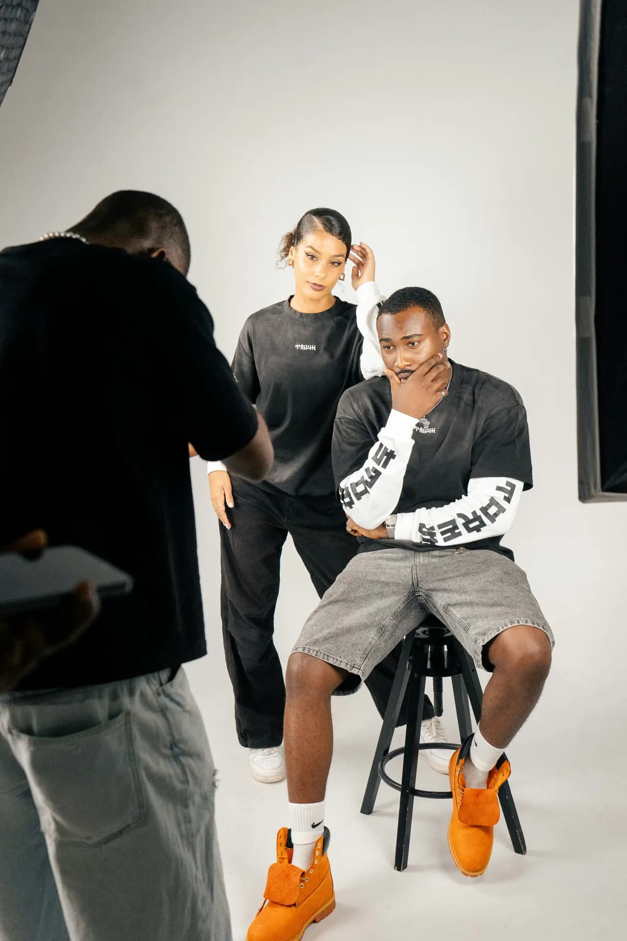 A behind-the-scenes fashion moment showing collaboration on set.